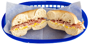 A sliced bagel sandwich with scrambled eggs and ham is placed on parchment paper in a blue plastic basket.